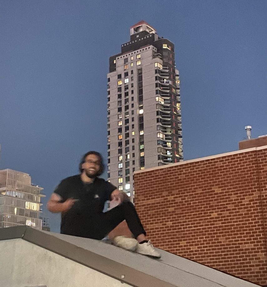 Josh sitting on a rooftop at dusk